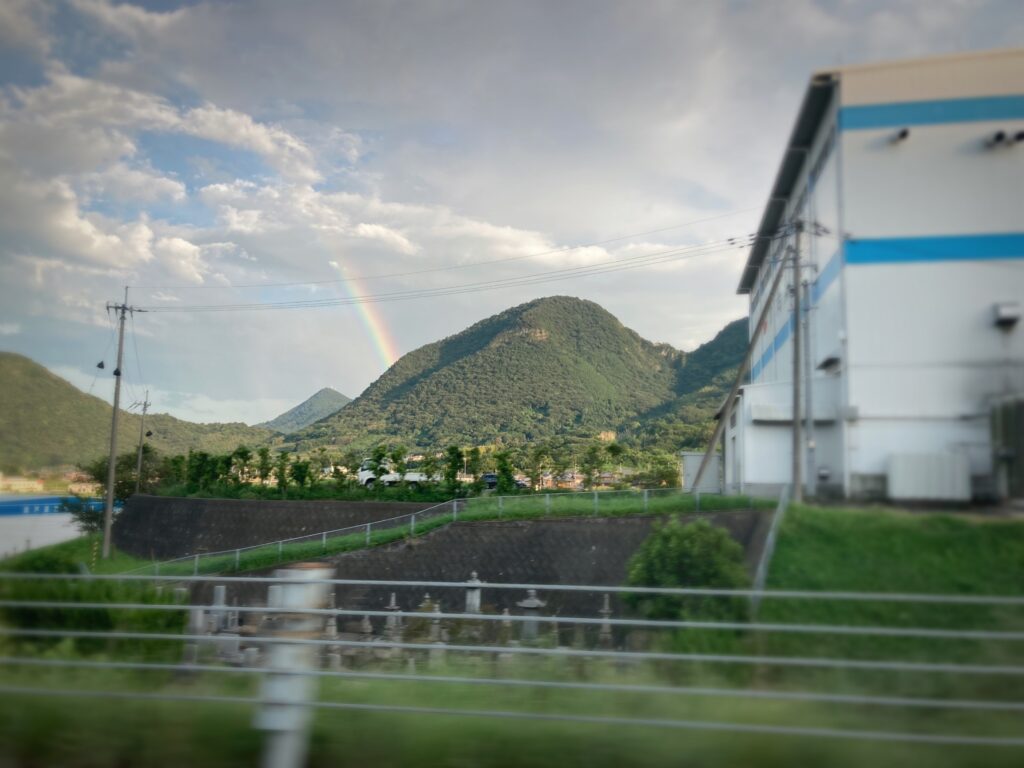 電車の窓から見える虹