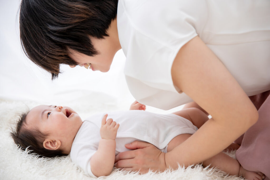 ママと赤ちゃんが触れあって笑っているようす