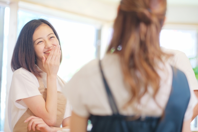 手がきれいな奥さんが、手を口に当てて笑っている